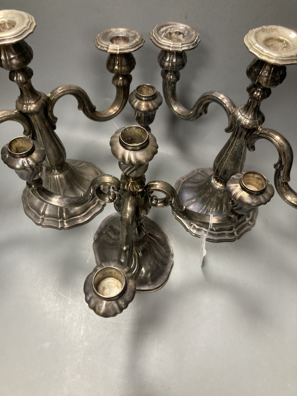 An early 20th century German 925 standard candelabrum and pr of candelabra